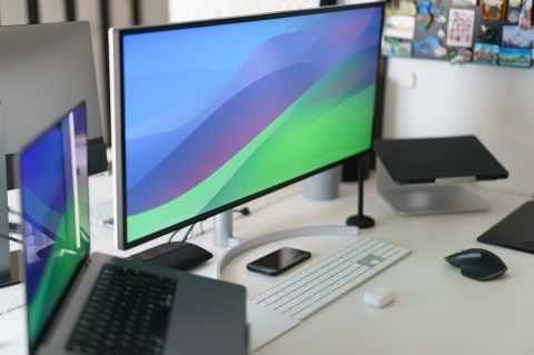 A desk with a computer monitor, laptop, keyboard, and mouse.